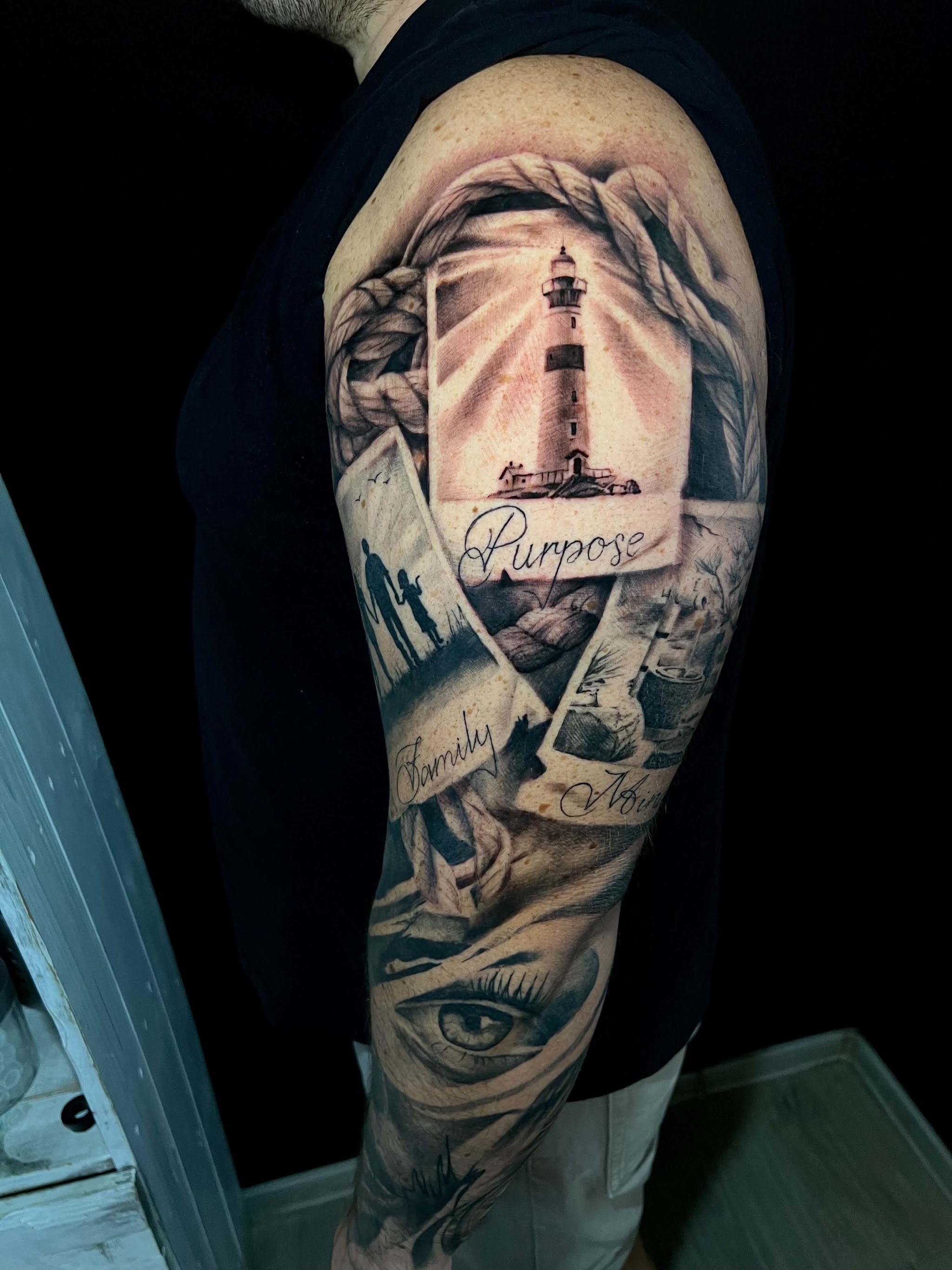 Volledige sleeve met een vuurtoren en het woord Purpose, zwart-grijs